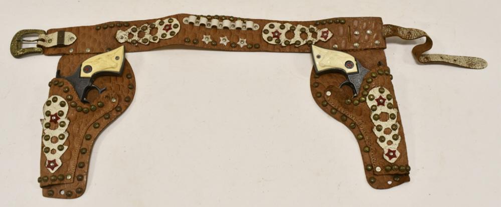 Hubley Texan Jr. Cap Gun Set w/ Leather Holster: Hubley Texan Jr. cap gun set with leather holster. The guns have some corrosion and wear from use and age. The holster has some cracking. Each gun measures approximately 8-1/2" long.