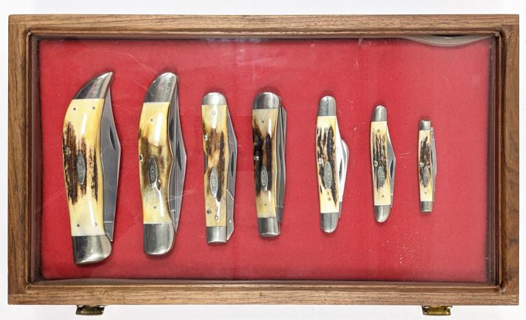 1976 Case XX 7pc Razor Edge Stag Knife Set: 7pc Stag handle folding knife set. 1976 Case XX grey etched letters set. Set is in wooden showcase, which is included. All knives appear unused.