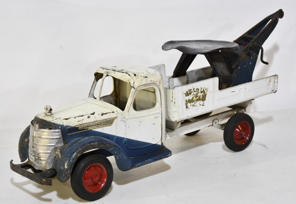 Buddy L International Ride On Wrecker Tow Truck: Buddy L International ride on wrecker tow truck. Original condition with some older overpaint in areas. The wheels are not original, and it is missing one headlight. Displays well with partilal Buddy