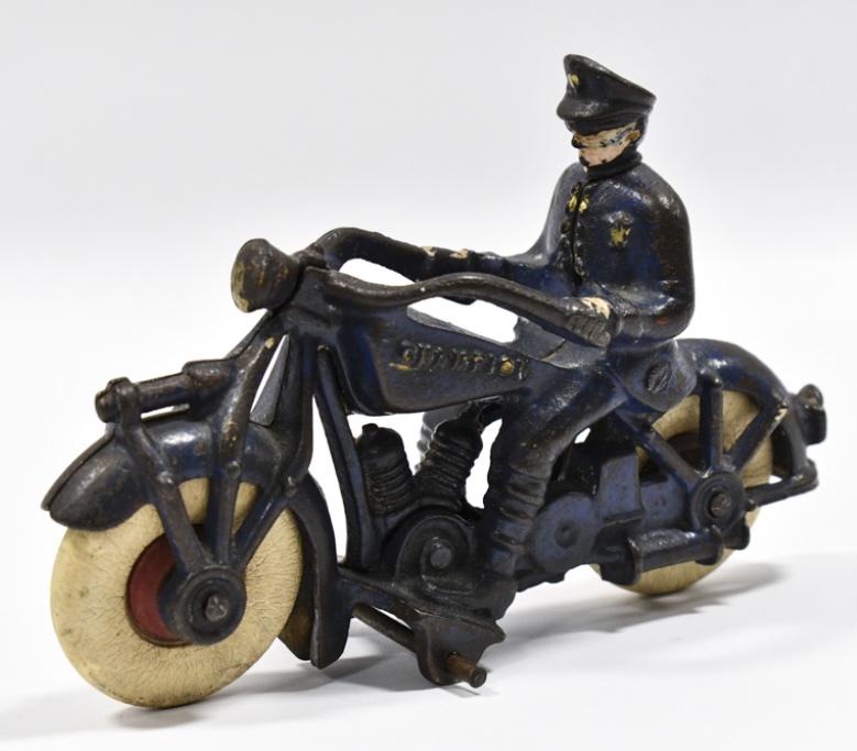 Cast Iron Champion Motorcycle w/ Police Rider: Cast iron Champion motorcycle with police rider. The motorycyle is missing one of the support wheels. The tires have some cracking from age. The bike has paint loss and wear from play and age. Measure