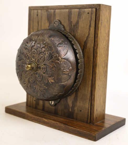 Antique Victorian Iron Mechanical Doorbell: 1872 Victorian Mechanical Doorbell with a worn bronze finish. Nice condtion for age. Mounted on wood. Bell measures 5" wide. With mount measures 8" across 8.25" tall
