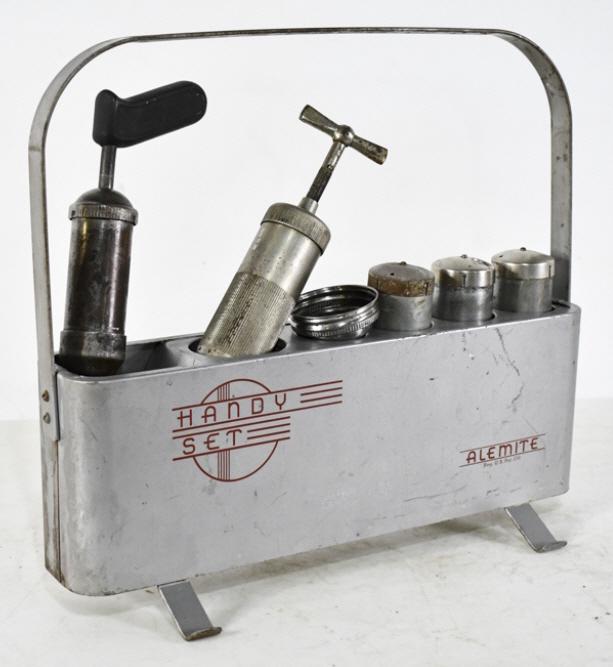 Vintage Alemite Handy Set Carrier w/ Grease Gun: Vintage Alemite handy set carrier with grease gun. Del claims that this was used for pedal cars back in the day. The set has some scratches and wear from use and age. Measures approximately 18-1/2" lo