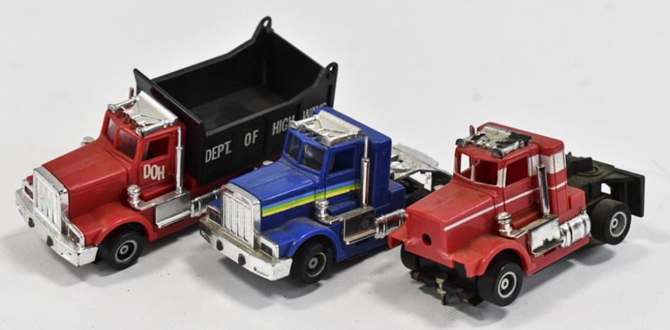 Tyco HO Scale Peterbilt Semi Trucks & Dump Truck: Tyco HO scale Peterbilt semi trucks and dump truck slot cars / trucks. The red semi is missing the grill. The blue and the red truck each missing one stack. All of the slot cars have some use wear.