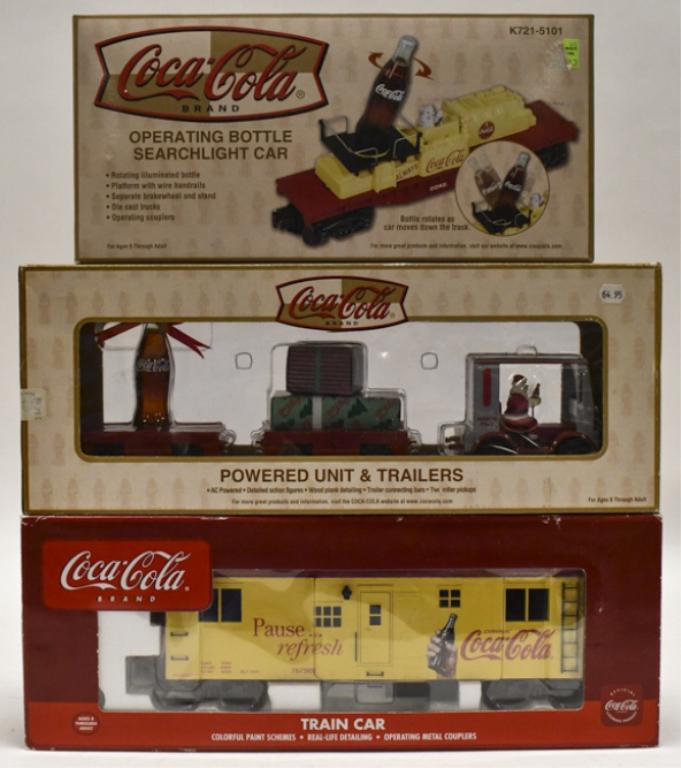 Coca-Cola Powered Unit & Trailers + Seachlight: Coca-Cola powered unit & trailers, Coca-Cola operating bottle searchlight car, Coca-Cola wood-sided travel car smoking, illuminated. Good condition in the boxes.