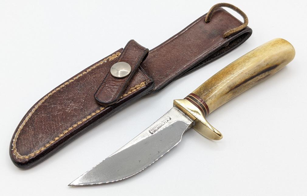 Vtg Randall Made Model 21 Little Game w/ Sheath: Vtg Randall Made Model 21 Little Game w/ Randall Sheath. Knife comes with smooth stag handle and brass guard. Knife is in used condition with scuffs and some pitting on the blade and some scuffs on th
