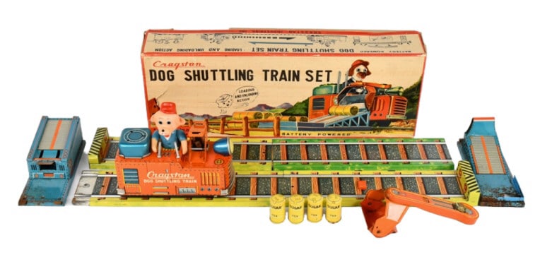 Cragstan Battery Op. Dog Shuttling Train Set w Box: Cragstan battery operated dog shuttling train set with the original box. The one loading station has a rust hole through it. The toy is untested, but the battery compartment is clean. The box has a pu