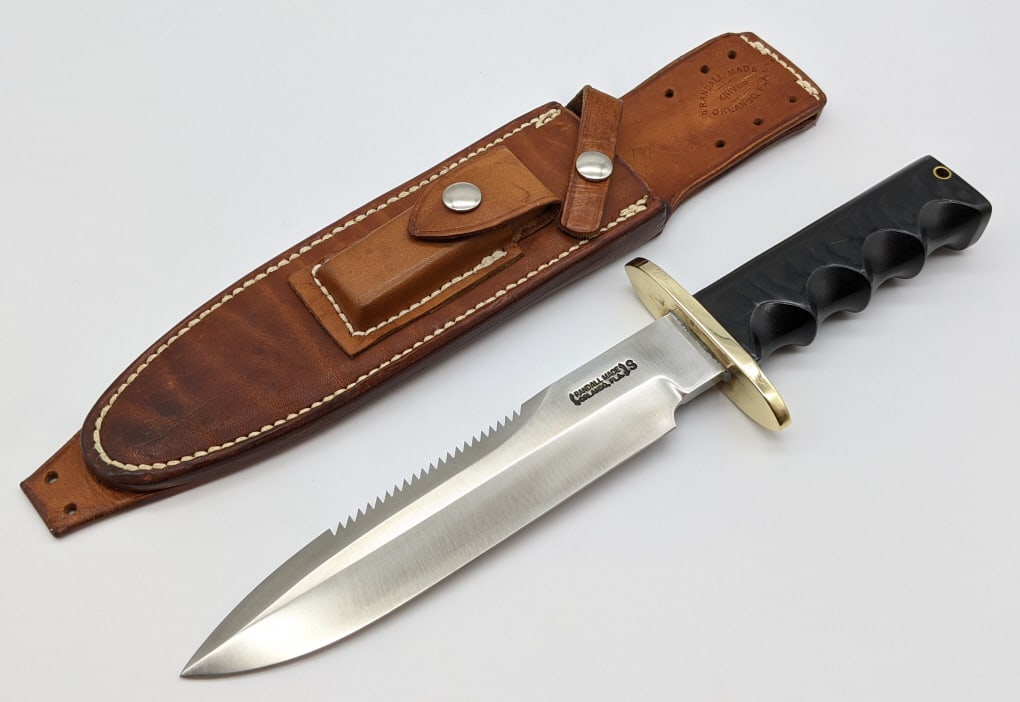 Vtg Randall Made Model 14 Attack w/ Randall Sheath: Vtg Randall Made Model 14 Attack w/ Randall Rough Back Sheath. Knife features stainless steel saw tooth blade, straight oblong brass hilt, and full tang black micarta handle with finger grooves and la