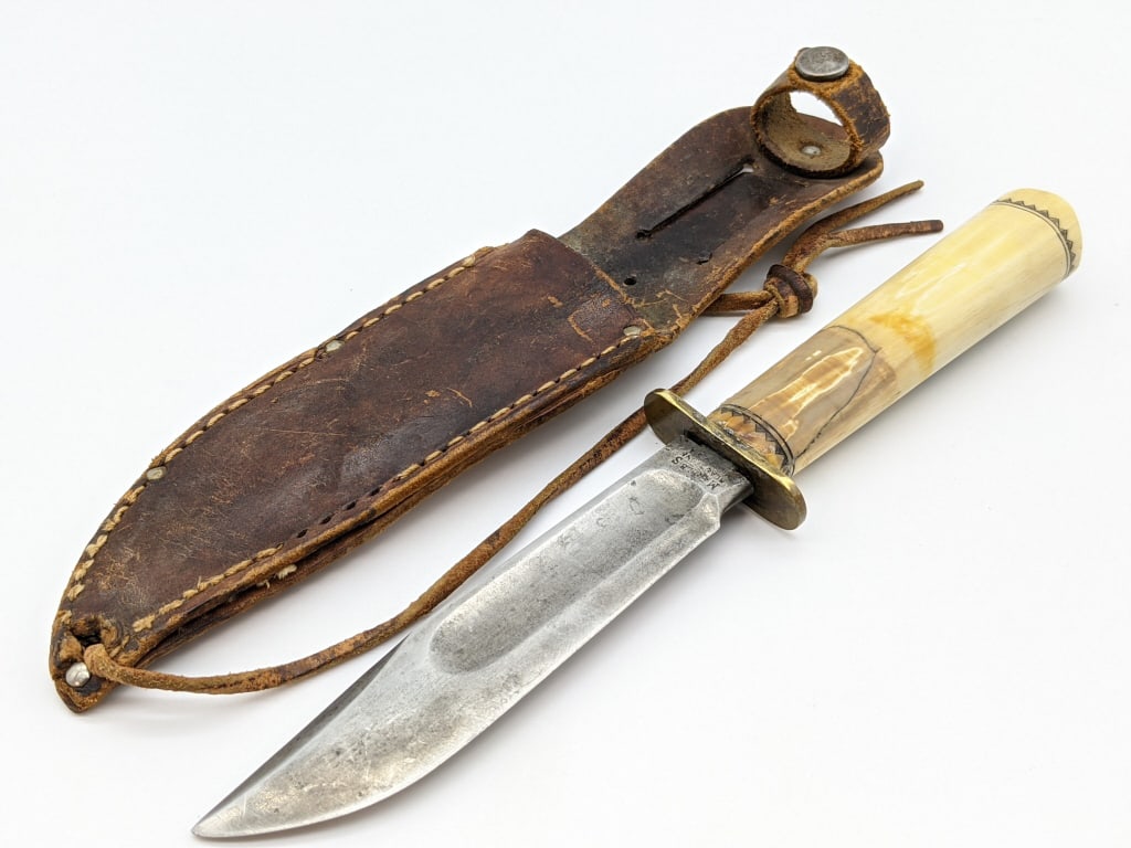 Marbles Carved Bone Left Serif Ideal Hunting Knife: Marbles Carved Bone Third Model Left Serif Ideal Hunting Knife w/ Woodcraft Sheath. Circa 1911-30 knife features very nice blade with light scratches, double hilt, and custom rehandles Inuit carved bo