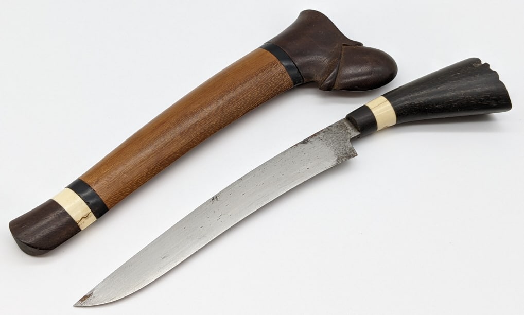 Early Malaysian Badek Knife w/ Wooden Sheath: Early Malaysian Badek Knife w/ Wooden Sheath. Knife features drop point blade and horn handle with bone ring inlay. Sheath is made of wood with carved throat, hard wood butt cap, and horn and bone rin