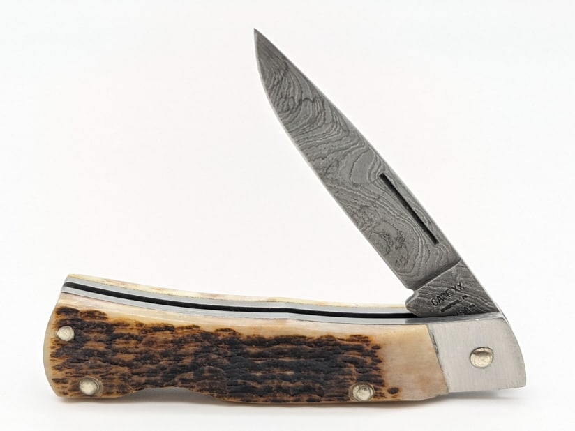 1989 Case XX Jig Bone Damascus Lockback ROG 61059: 1989 Case XX Jig Bone Damascus Lockback ROG 61059. Knife is in like new condition. Blade length of 2-1/2in and overall length of 5-3/8in when open.