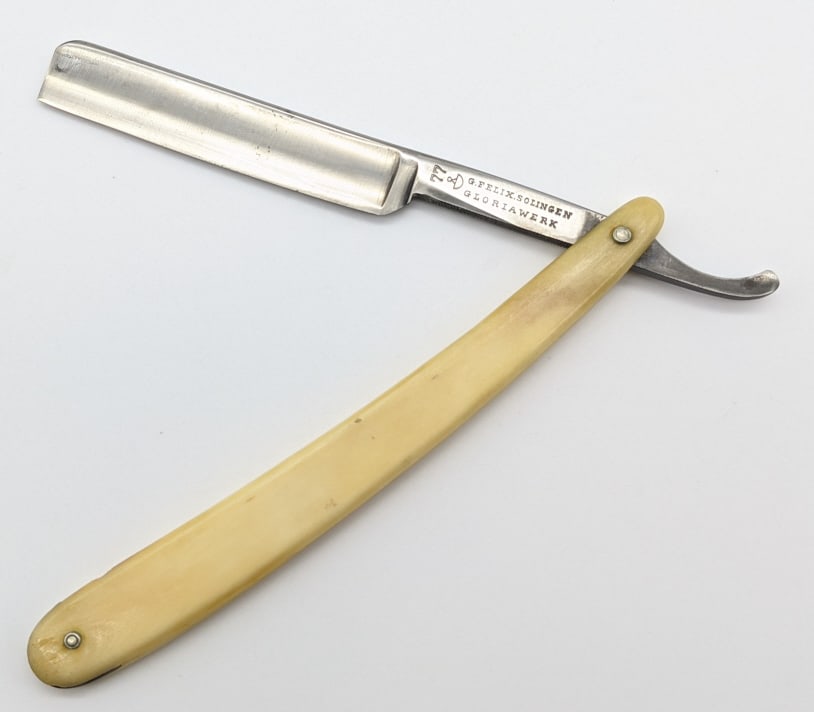 G. Felix Solingen Bone Handle Straight Razor: G. Felix Solingen Gloriawerk Bone Handle Straight Razor. Razor features a smooth bone handle and finger grooves on the tang. Razor is in nice condition with minor carbon spotting on the blade. Overall