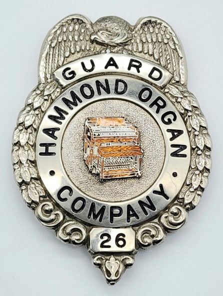 Obsolete Hammond Organ Co. Guard Badge #26: Obsolete Hammond Organ Co. Guard Badge #26. Nice badge with an organ in the center with red enamel detailing. Measures 2-3/4in.