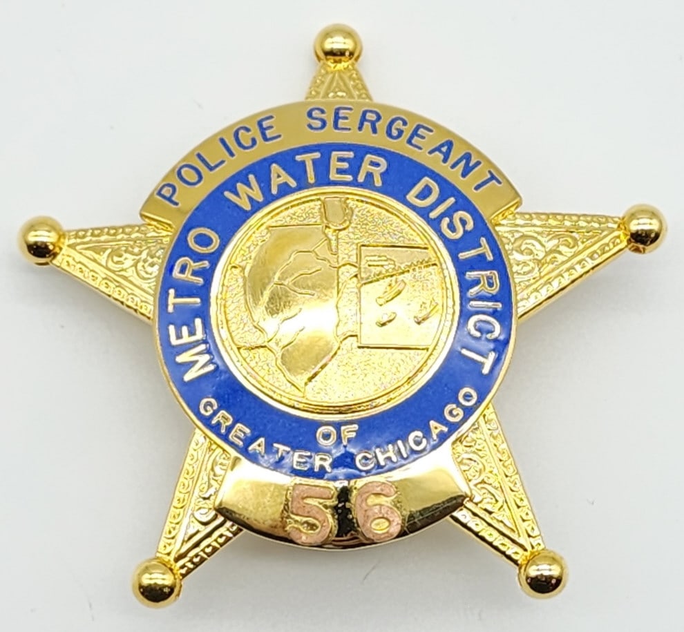 Obsolete Chicago Metro Water Police Sergeant Badge: Obsolete Chicago Metro Water District Police Sergeant Badge #56. Badge is in nice condition with scroll work, copper finish numbers, pin back, and is marked Nielsen Mfg. Chehalis, WA. Measures 2-3/4in