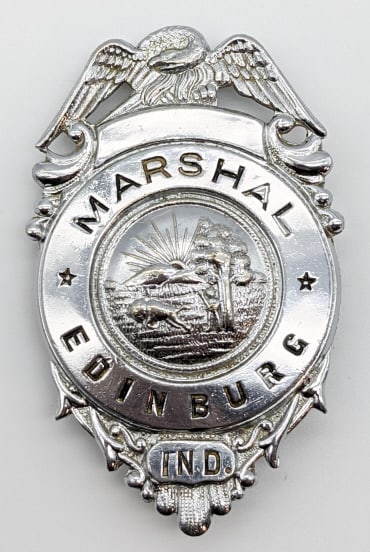 Obsolete Edinburg Indiana Marshal's Badge: Obsolete Edinburg Indiana Marshal's Badge. Badge is in nice condition with some finish loss, eagle topper, pin back, and is unmarked. Measures 3in.