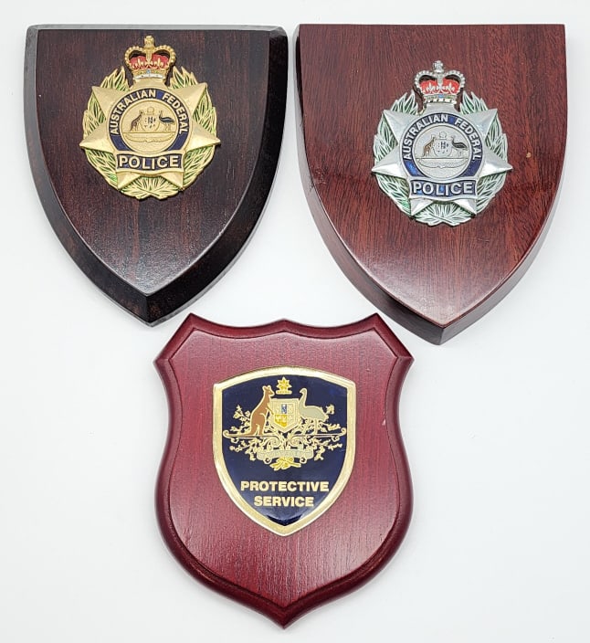 3) Australian Federal Police Force Badges: 3) Australian Federal Police Force Badges on Plaques. All are mounted on a wooden plaque and display nicely together. Largest measures 6-3/4in.