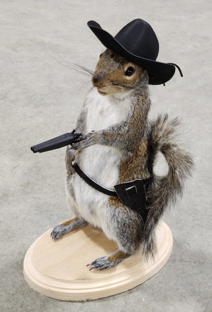 Shotgun Packin' Squirrel with Bandolieer & Hat: Shotgun Packin' Squirrel with Bandolieer & Hat. Piece is in new condition and displays nicely on wooden base. Overall measures approx 5in wide x 10-1/2in tall x 7in deep.