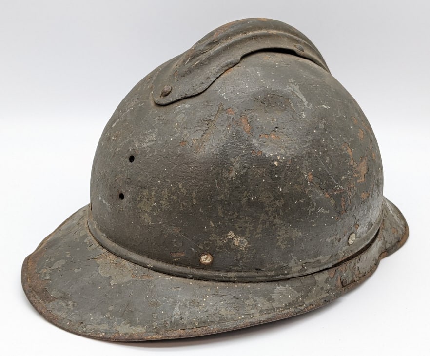 WW1 French M15 Adrian Helmet: WW1 French M15 Adrian Helmet. Helmet comes with the original leather liner and is in well used conditon with various dent and paint loss from age. Overall measures 8-1/2in wide x 12in long x 6in tall.