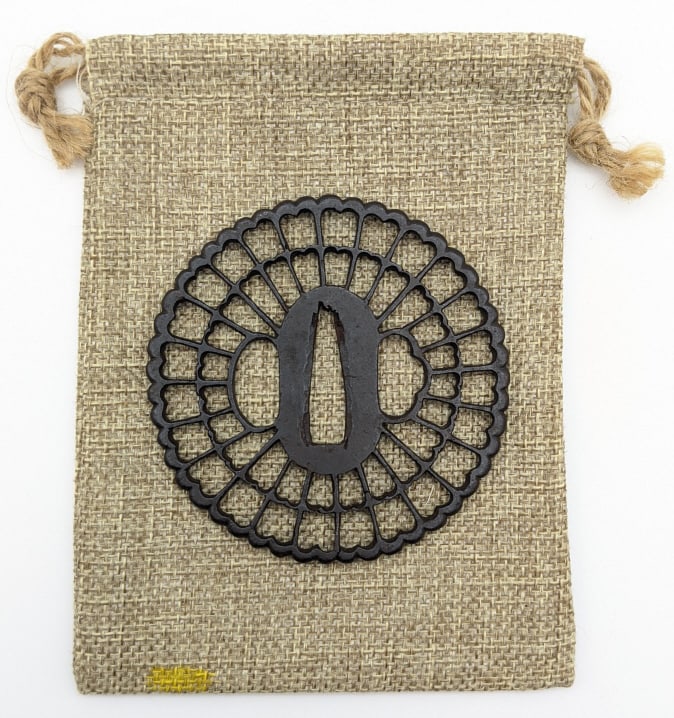 WW2 Japanese Decorated Tsuba Sword Guard: WW2 Japanese Decorated Tsuba Sword Guard. Guard features a skeletonized design in the shape of a chrysanthemum. Guard is in very nice condition with some light pitting and wear from use and age. Comes