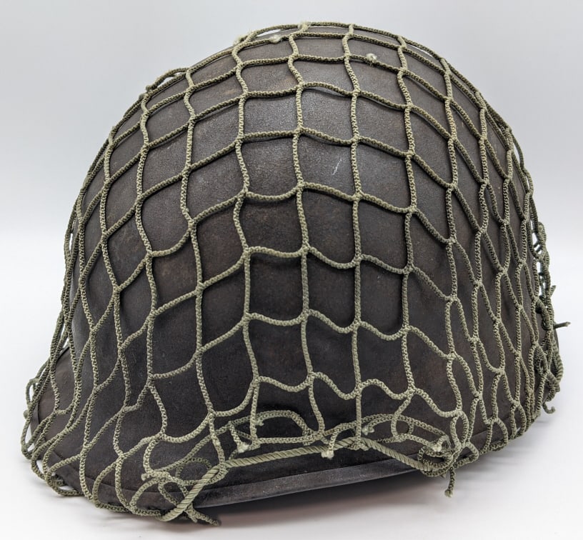 WW2 US M1 Military Helmet w/ Camo Netting: WW2 US M1 Military Helmet w/ Camo Netting. Helmet is in nice condition with light wear on the outside, but is missing the liner.