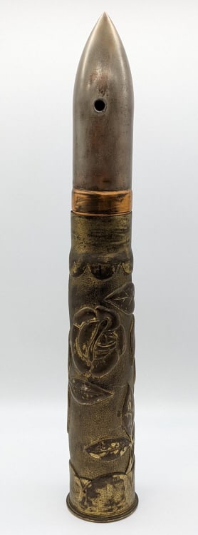 WW2 Trench Art Artillery Shell w/ Projectile: WW2 Trench Art Artillery Shell w/ Projectile. Shell displays a rose with a stippled backgrounds and scalloped edges. The projectile has been drilled for deactivation. Measures 19-1/2in tall.