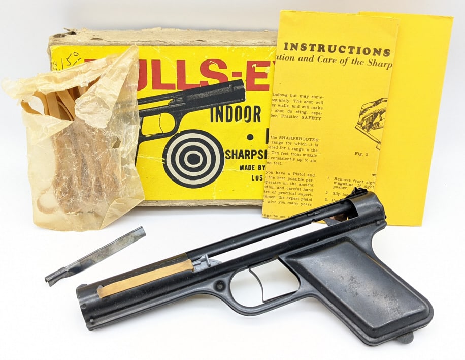 Bulls-Eye MFG. Sharp Shooter Rubber Band Gun: Bulls-Eye MFG. Sharp Shooter Rubber Band Gun Indoor Shooting Kit w/ Original Box and Instructions. Pistol features stamped frame construction with plastic cocking piece. Box is in nice aged condition 