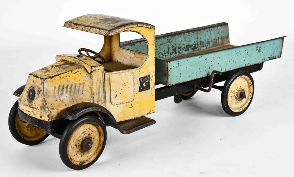 Steelcraft Mack Dump Truck: Steelcraft Mack dump truck. The truck is missing the tailgate. It has paint loss, discoloration, and wear from play and age. Displays well with good patina. Measures approximately 25" long.