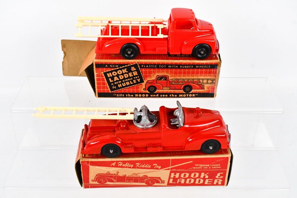 Hubley Hook & Ladder No. 463 & No. 324 w/ Boxes: Hubley hook & ladder No. 463 fire truck with the original box and Hubley No. 324 plastic hook & ladder truck with the original box. The boxes have some tape repair, wear, and loose end flaps from age.