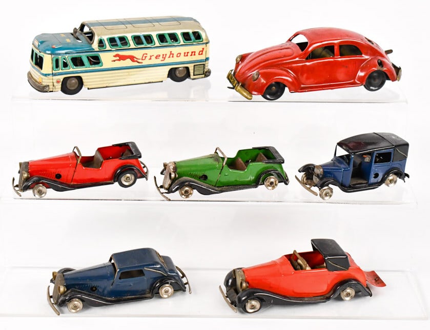 Tri-Ang Minic Cars, Volkswagen, & Greyhound Bus: Lot includes (5) Tri-Ang Minic windup tin windup cars, U.S. Zone Germany tin windup Volkswagen Beetle, and KKK Japan tin battery op. Greyhound bus. Most of the Tri-Ang cars are missing the tires. All 