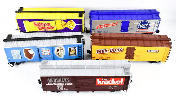 (5) G Scale Train Boxcars: Lot of five G Scale train boxcars. Includes a Good Humor, Sugar Daddy, York, Hershey's, and Milk Duds. All are in good condition with some wear from use / display.