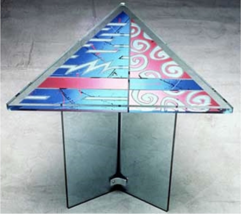 Joan Irving Geometric Etched Glass Triangle Table: Original geometric acid etched reversed painted triangle glass table by listed California artist Joan Irving. The triangle top table features lines and shapes and is signed and dated 1990. The base is