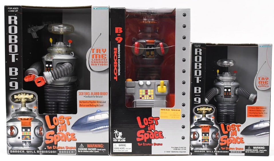 (3) NOS Lost In Space B-9 Robot Toys In Boxes: Lot of three new old stock Lost In Space B-9 Robot toys factorry sealed in original boxes. Lot includes the 8in figure by Trendmasters , 10 in figure by Trendmasters, and the remote control figure by