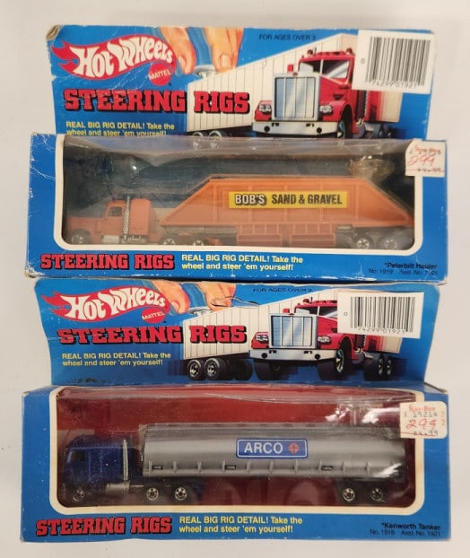 (2) Hot Wheels Steering Rigs In Packages: Lot includes two original Hot Wheels Steering Rigs semi trucks in the original packaging. It includes a No. 1918 Kenworth ARCO tanker truck and a No. 1919 Peterbilt Bob's Sand & Gravel hauler truck. T