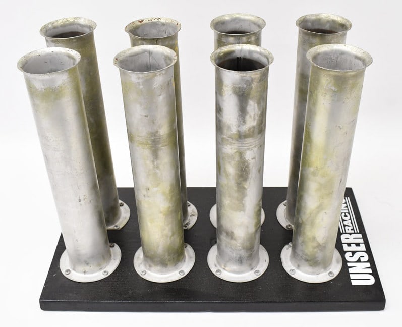 Unser Race Team Velocity Stacks: These aluminum velocity stacks came from a V8 engine out of the Unser Race Shop. The stacks are mounted on a wooden base. A great display piece and conversation starter. The stacks have some oxidation