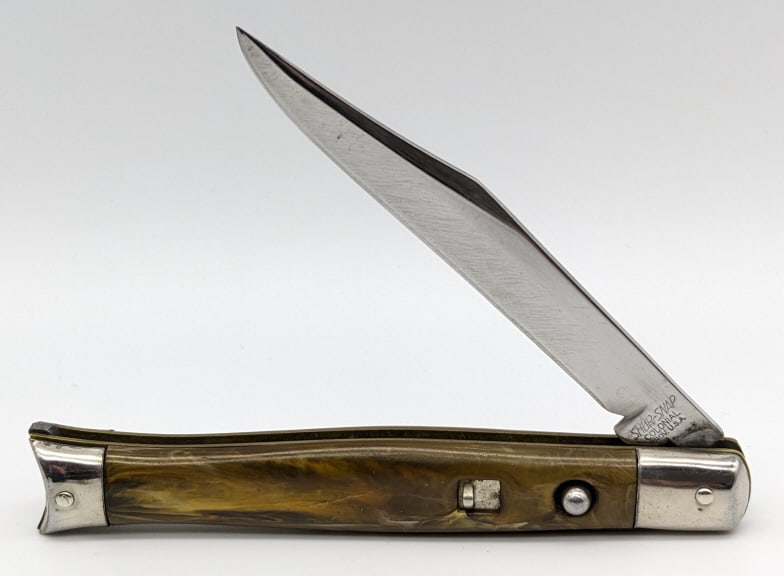 Shur-Snap Colonial Marbled Fishtail Switchblade: Shur-Snap Colonial Marbled Fishtail Switchblade. Knife is in nice condition with some polished scratches from sharpening. Blade spring is strong and has some play when open. Blade length of 3-1/2in an