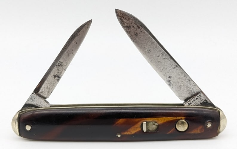 Schrade Cut Co Tortoise Double Switchblade: Schrade Cut Co Tortoise Double Switchblade Knife. Knife is in aged condition with carbon spotting and material loss, and celluloid tortoise shell handle scaled. Both blade springs are strong and have