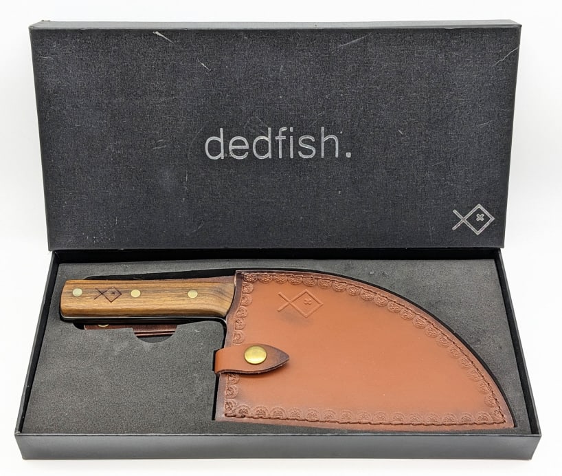 NIB Dedfish Kitchen Cleaver w/ Sheath: NIB Dedfish Kitchen Cleaver w/ Sheath. Features a forged finish blade, and Pakka wood handle scales. Knife is in new condition. Blade length of 7in and overall length of 11-3/4in.
