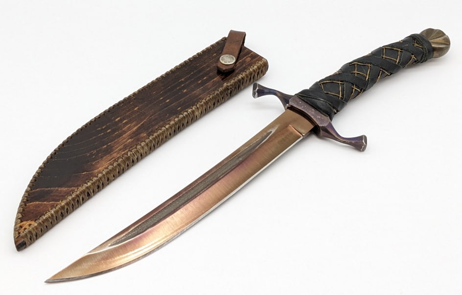 Sabersmith Golden Elven Dagger w/ Sheath: Sabersmith Golden Elven Dagger w/ Sheath. Features a fullered curved blade, serpentine faceted double guard, leather and wire wrapped handle, and fluted pommel. The sheath is made of wood with fiber l