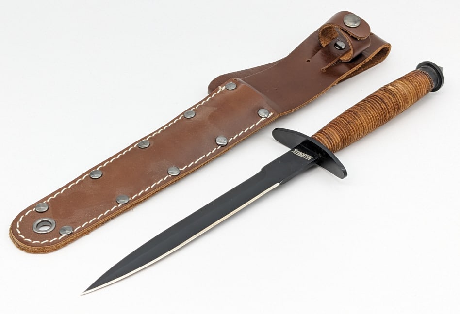 Marble's MR429 V-42 Dagger w/ Sheath: Marble's MR429 V-42 Dagger w/ Sheath. Features a black finish double edged blade, upturned double guard, stacked leather handle, and skull crusher pommel. Knife is in like new condition. Blade length