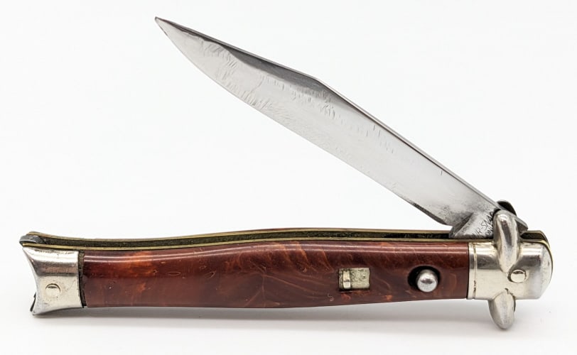 Shur-Snap Bowtie Fishtail Switchblade Knife: Shur-Snap Bowtie Fishtail Switchblade Knife. Knife is in nice used condition with a polished blade with some material loss and scratches, polished bolsters with scuffs, and marbled red plastic handle 