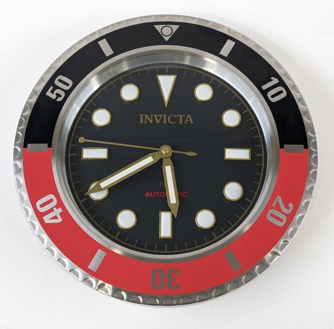 Invicta Pro Diver Wall Clock In Box: Invicta Pro Diver wall clock in the original box. The metal clock has a black and red bezel and comes with a second hand. The condition is near new and it measures 14" in diameter.