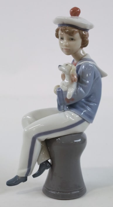Lladro Porcelain "Seaside Companions" Figurine: Lladro Spain porcelain figurine titled "Seaside Companions" featuring a Dachshund and a young sailor. Great quality and detail. Marked on the base, #6196. Measures approximately 8-1/2" tall x 2-1/2" a