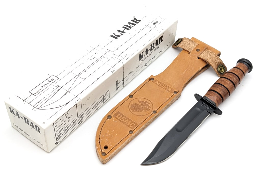 NIB 5in Ka-Bar Fighting Knife w/ Sheath: NIB 5in Ka-Bar Fighting Knife w/ Sheath. Features a black finish blade and stacked leather handle. Knife is in new condition. Blade length of 5-1/4in and overall length of 9-3/8in.