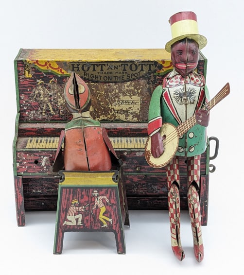 Unique Art Tin Windup Hott An Tott Band: Unique Art tin litho windup Hott 'an' Tott band. The piano has heavy paint loss / flaking. The windup mechanism needs work. Measures approximately 7" across.