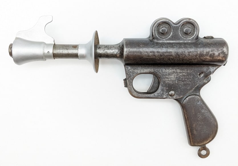 Daisy MFG. Co. Buck Rogers Space Ray Pop Gun: Daisy MFG. Co. 25th Century space ray pop gun. When the gun is cocked and the trigger is pulled the gun makes a popping noise. The gun has scratches, tarnishing, and wear from age. The silver heat shi