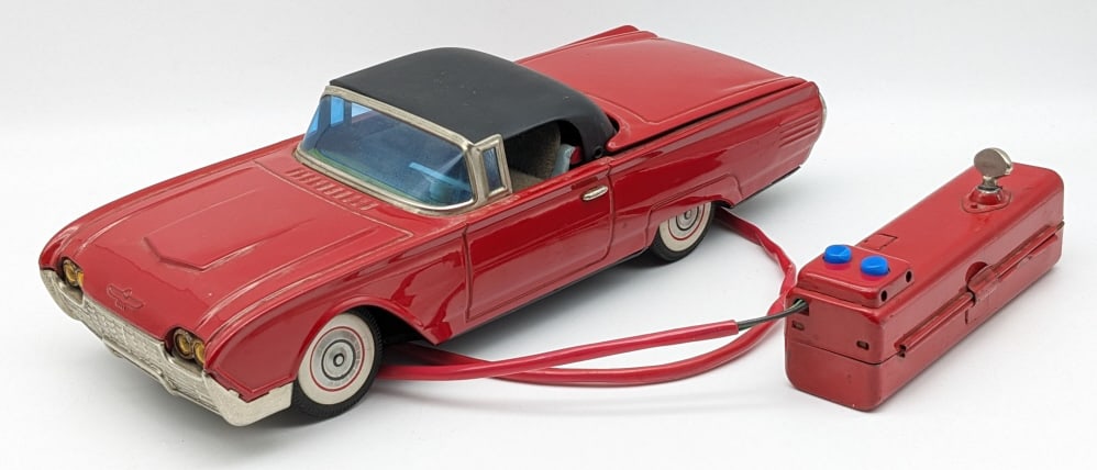 Vintage Tin Battery Operated Ford Thunderbird Car: Vintage Tin Battery Operated Ford Thunderbird Car. The steering control isn't original to the remote. The car is in good condition with some scuffs and wear with age. Measures approximately 11-1/4" lo