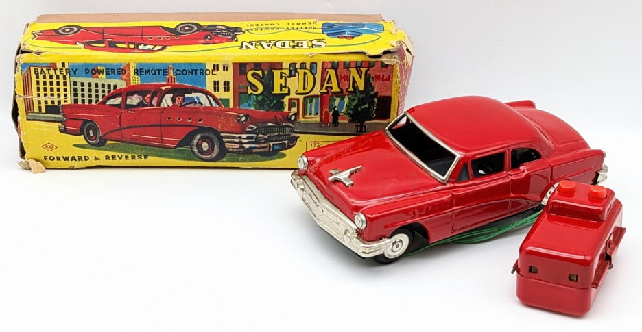 Cragstan Tin Battery Powered Sedan w/ Box: Cragstan Tin Battery Powered Sedan with Box. The car is in great condition with some scuffs and wear with age. The box lid is missing the small end on the left side and has tears. Measures approximate