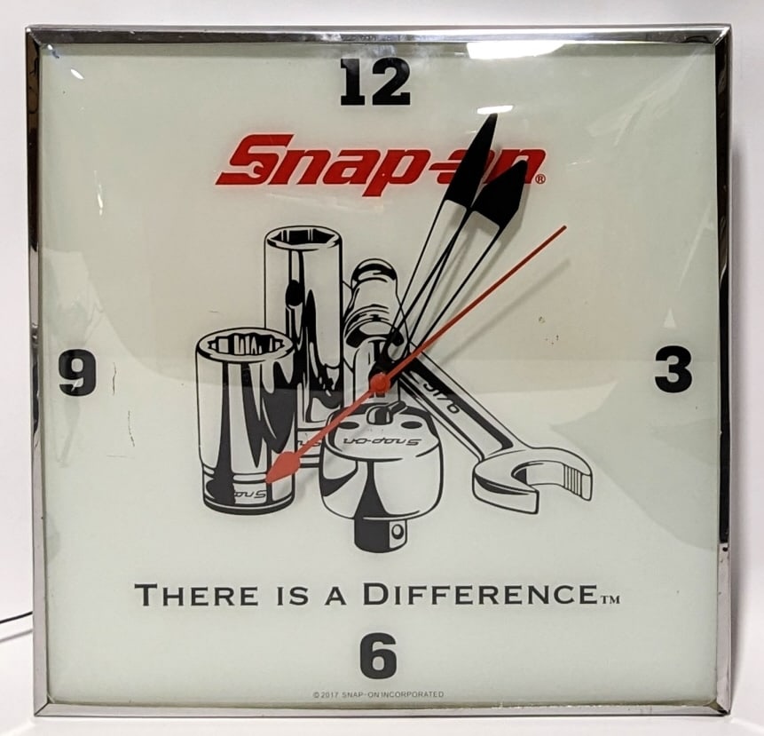 2017 Snap-On Lighted Advertising Clock: 2017 Snap-On lighted advertising clock. The clock has some paint loss to the face and surface scratches to the metal can. The clock runs and the lights work. Measures approximately 15" tall by 15" acr
