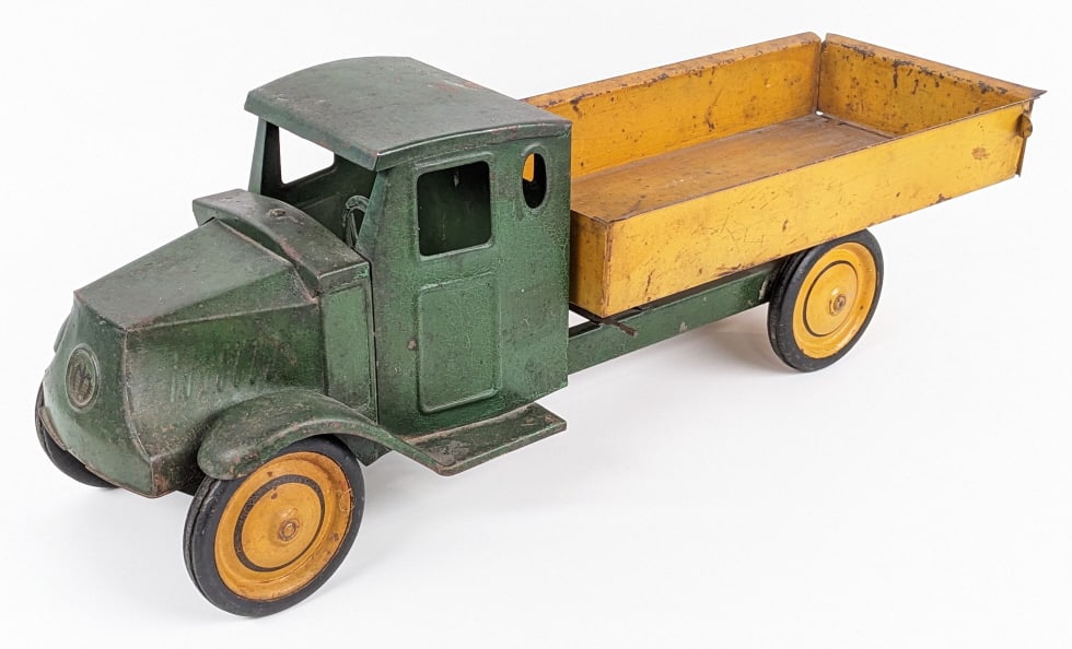 Steelcraft Mack Dump Truck: Steelcraft Mack dump truck. The truck has alligatoring to the paint and paint loss, and wear from play and age. Appears to have been painted over along time ago with the door decals somewhat showing. 