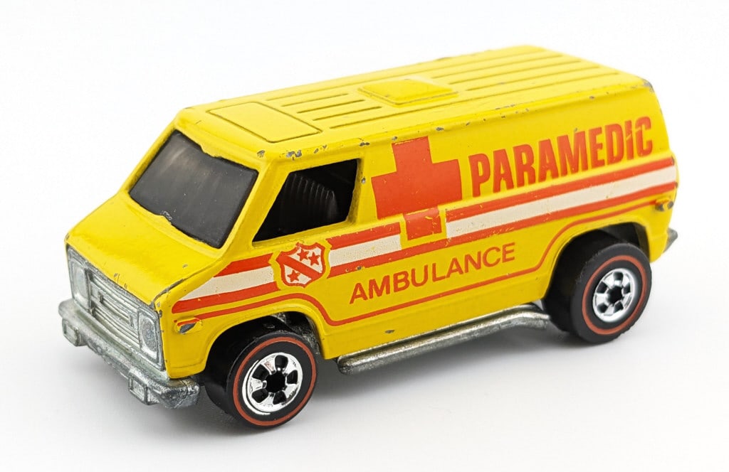 Hot Wheels Redline Flying Colors Yellow Paramedic: Hot Wheels Redline Flying Colors yellow paramedic with chrome metal base. The car has some edge wear, paint chips, good wheels, and clean base.
