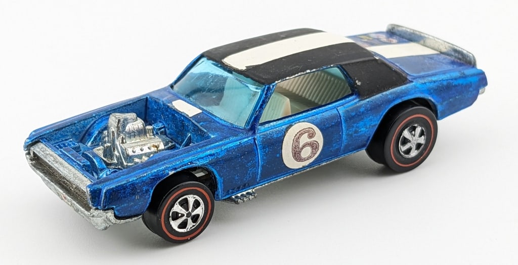 Hot Wheels Redline Spoilers Blue TNT-Bird: Hot Wheels Redline The Spoilers Blue TNT-Bird with applied decals on the rear. The car has some toning mostly in the engine bay, micro chips, and age wear.